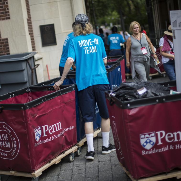 Folks assisting others with moving into a dormitory