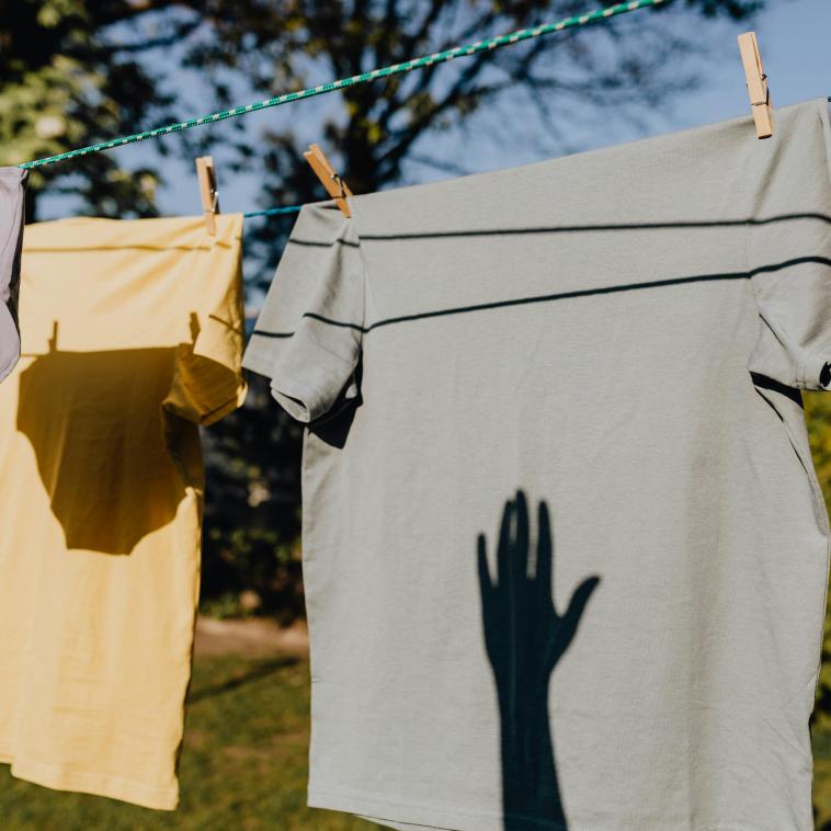 Clothing on a line with a shadow of a hand